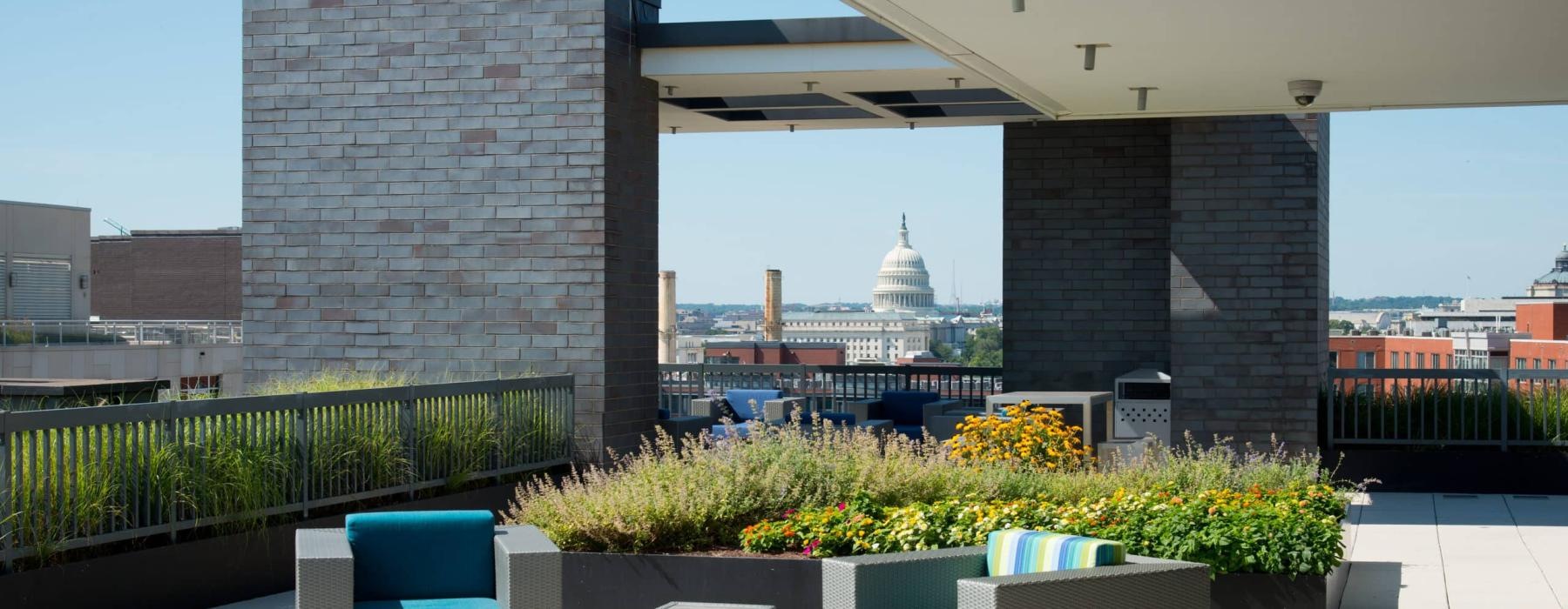 a patio with a couple of chairs and a large building in the background