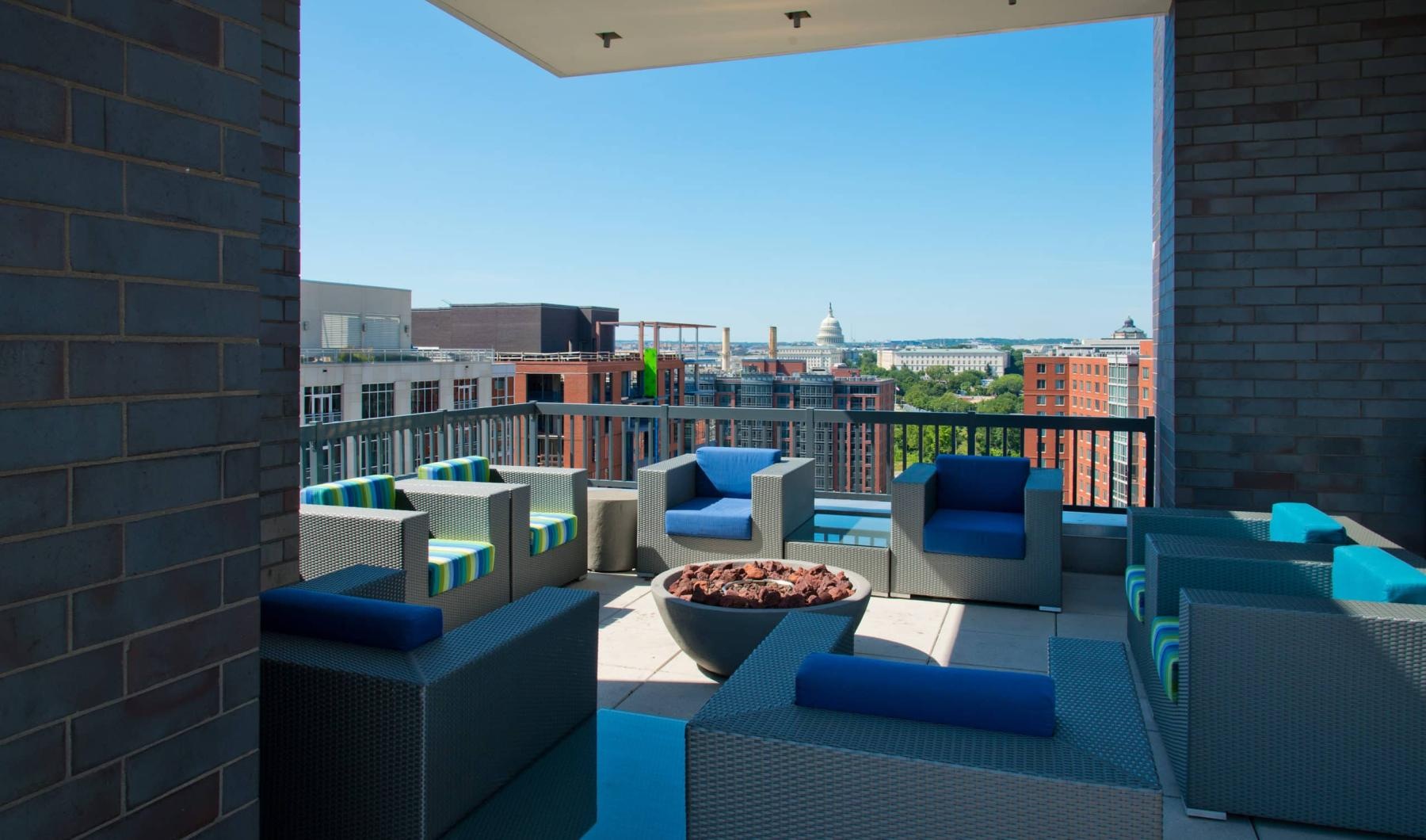 Settle into comfort at Onyx on First a patio with blue chairs and a view of a city